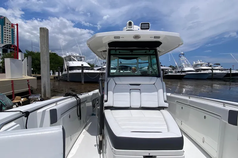Slide: The Image of 2022 Blackfin 332 CC boat docked at marina under blue sky. - 21