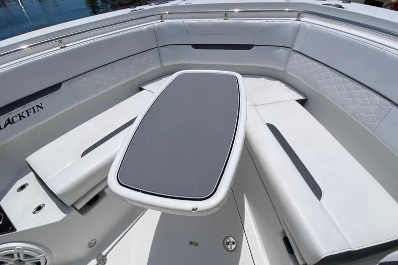 Slide: The Image of 2022 Blackfin 332 CC boat interior with cushioned seating and table. - 22