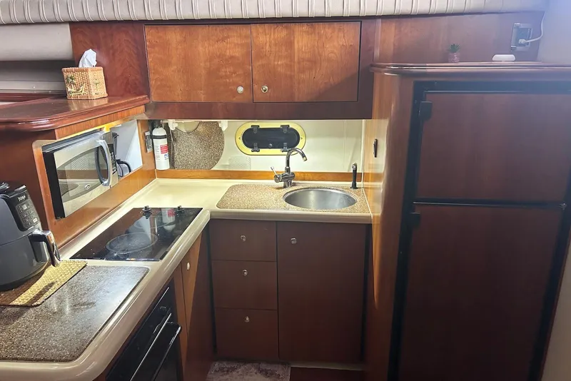 Slide: The Image of 2001 Cruisers Yachts 3750 Motoryacht kitchen with wood cabinetry, sink, and appliances. - 17