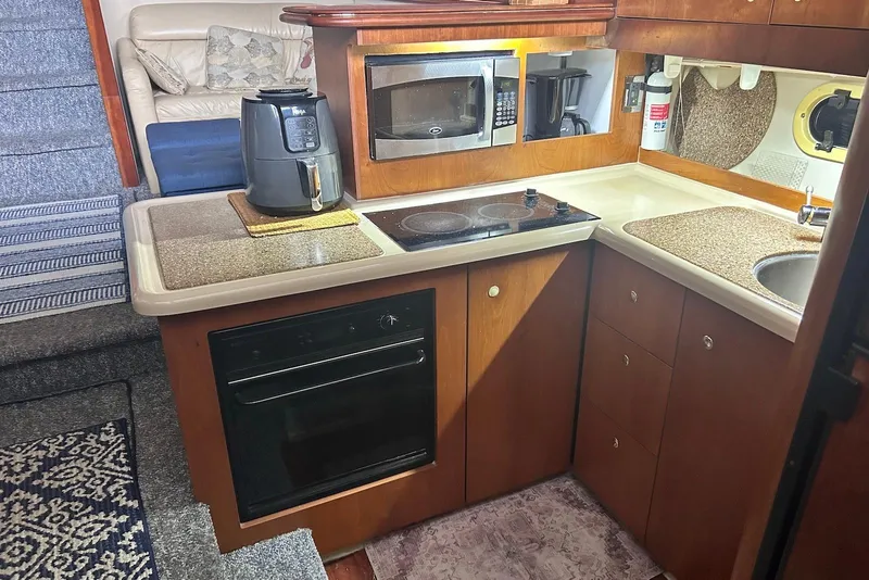 Slide: The Image of 2001 Cruisers Yachts 3750 Motoryacht kitchen with stove, microwave, and air fryer. - 18
