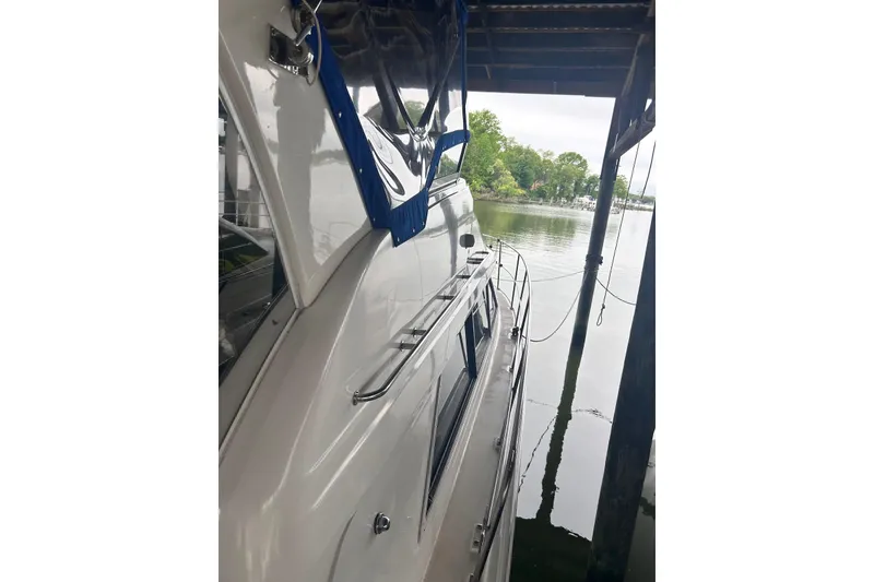 Slide: The Image of 2001 Cruisers Yachts 3750 Motoryacht docked, featuring sleek design and reflective water view. - 2