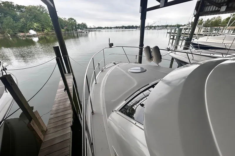 Slide: The Image of 2001 Cruisers Yachts 3750 Motoryacht docked by serene waterfront. - 4