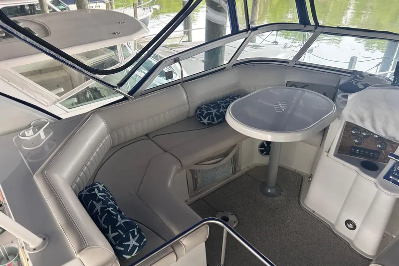 Slide: The Image of 2001 Cruisers Yachts 3750 Motoryacht interior with seating and table, featuring nautical-themed cushions. - 7