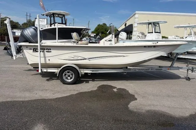 The Image of 2019 Carolina Skiff 218 DLV boat on trailer, parked outdoors in a dealership lot. - 1