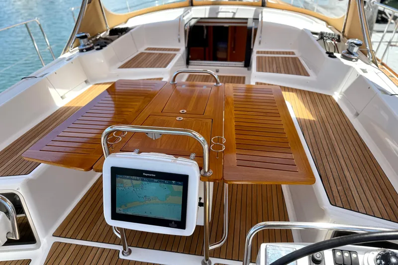 Slide: The Image of Cockpit of 2018 Jeanneau 58 yacht with wooden table and navigation display. - 33