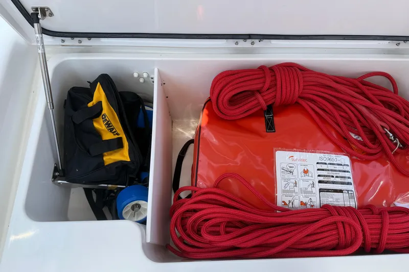 Slide: The Image of Storage compartment on a 2018 Jeanneau 58 yacht with red ropes and a tool bag. - 48