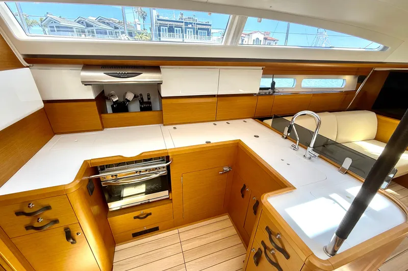 Slide: The Image of Luxurious 2018 Jeanneau 58 yacht interior kitchen with modern appliances and sleek wood finish. - 5