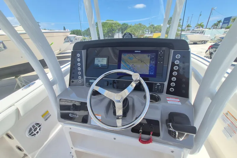 Slide: The Image of 2023 Robalo R230 Center Console boat dashboard with navigation display and steering wheel. - 10