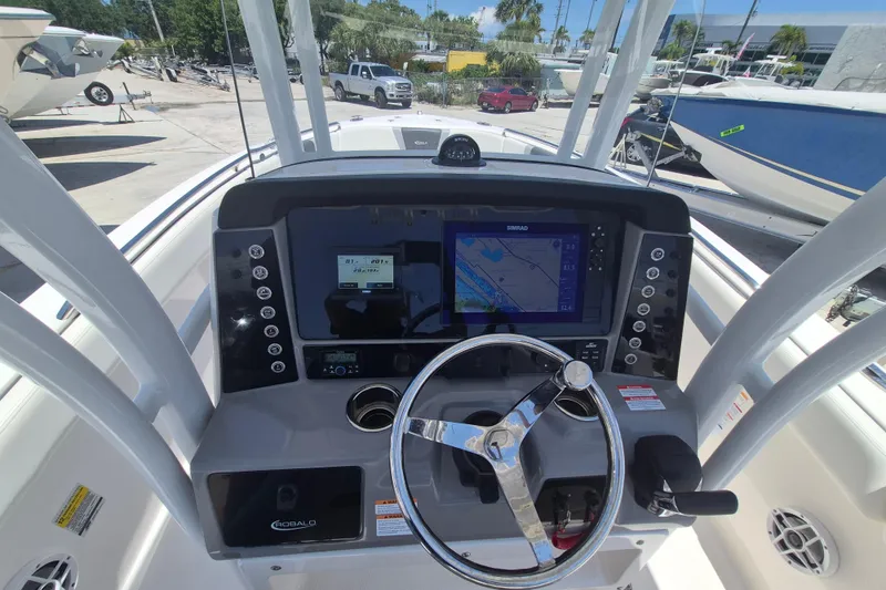 Slide: The Image of 2023 Robalo R230 Center Console boat dashboard with steering wheel and navigation display. - 12