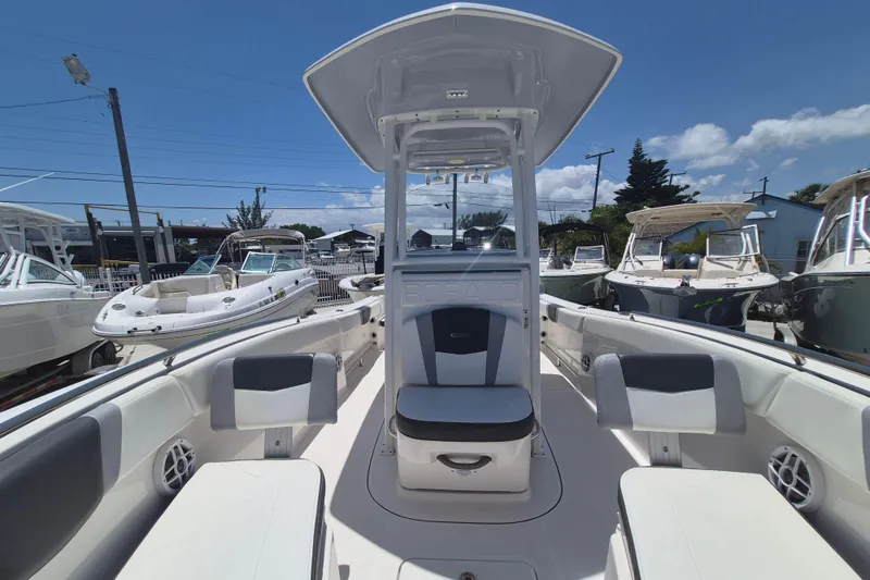 Slide: The Image of 2023 Robalo R230 Center Console boat with seating, docked under clear blue sky. - 14