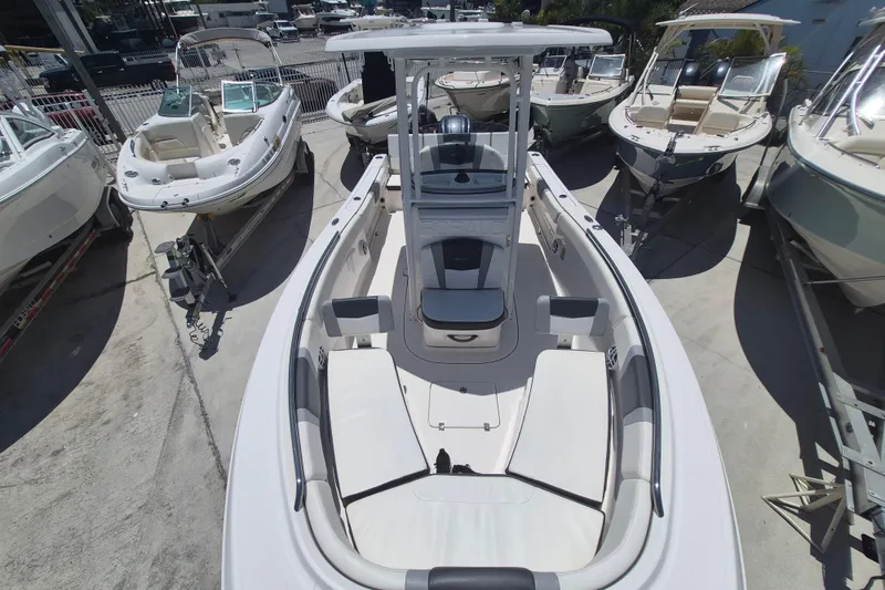 Slide: The Image of 2023 Robalo R230 Center Console boat displayed among other boats at a dealership. - 15