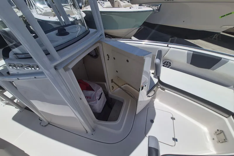 Slide: The Image of 2023 Robalo R230 Center Console boat interior with storage compartment open. - 17