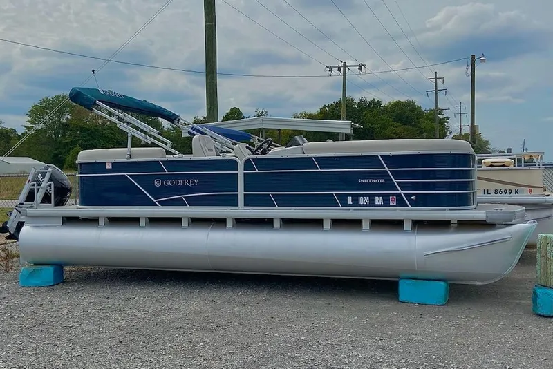 The Image of 2021 Godfrey Sweetwater 2286 SBX pontoon boat on display, featuring a sleek blue design. - 1