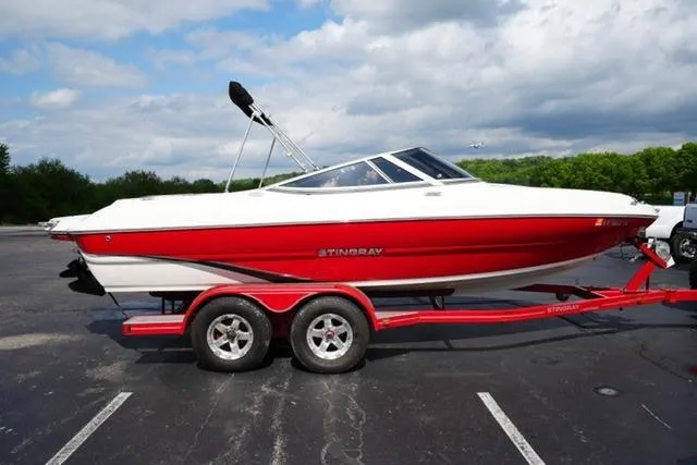 Slide: The Image of 2015 Stingray 208 LR boat on a red trailer in a parking lot. - 11
