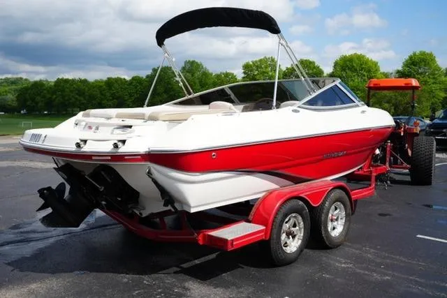 Slide: The Image of 2015 Stingray 208 LR boat on trailer, red and white design, parked outdoors. - 12