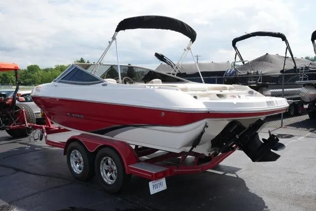 Slide: The Image of 2015 Stingray 208 LR boat on trailer, red and white design, parked outdoors. - 14