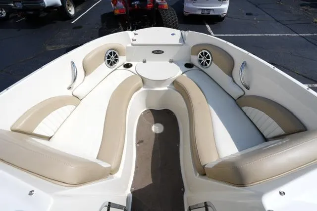 Slide: The Image of 2015 Stingray 208 LR boat interior with beige seating and speakers. - 16