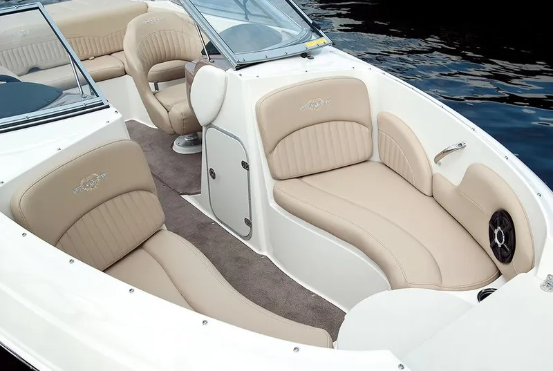 Slide: The Image of Manufacturer Provided Image: 2015 Stingray 208 LR boat interior with beige seating and water in the background. - 5