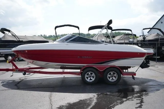 Slide: The Image of 2015 Stingray 208 LR boat on trailer, red and white design, parked outdoors. - 8