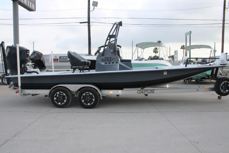 Slide: The Image of 2019 JH Performance Outlaw 230 boat on trailer, side view, parked outdoors. - 1