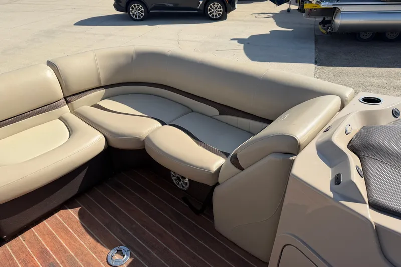 Slide: The Image of 2015 Crest Classic 230 SLC boat interior with beige seating and wood flooring. - 10