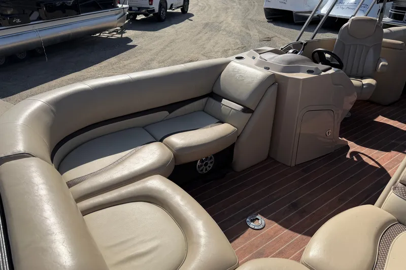 Slide: The Image of Interior of 2015 Crest Classic 230 SLC pontoon boat with beige seating and wood flooring. - 14