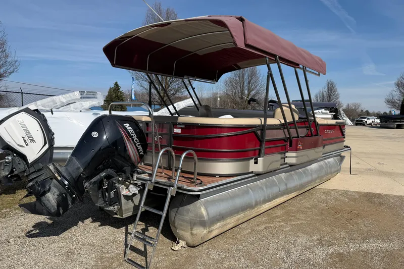 Slide: The Image of 2015 Crest Classic 230 SLC pontoon boat with Mercury outboard motor, parked outdoors. - 3