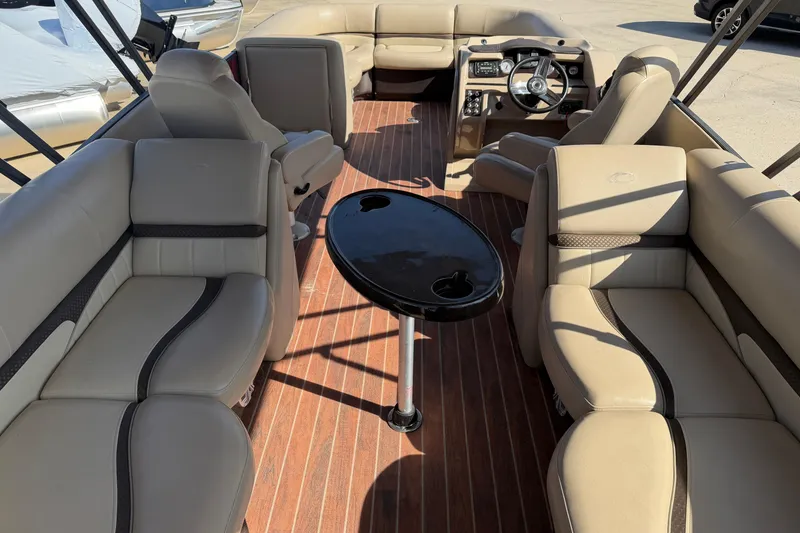 Slide: The Image of 2015 Crest Classic 230 SLC boat interior with beige seating and a central table. - 4