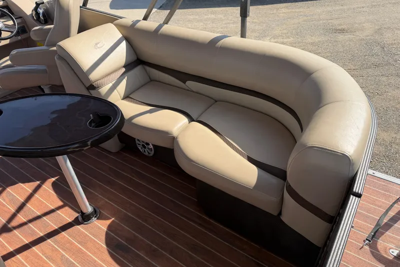 Slide: The Image of 2015 Crest Classic 230 SLC boat interior with beige seating and a black table. - 5