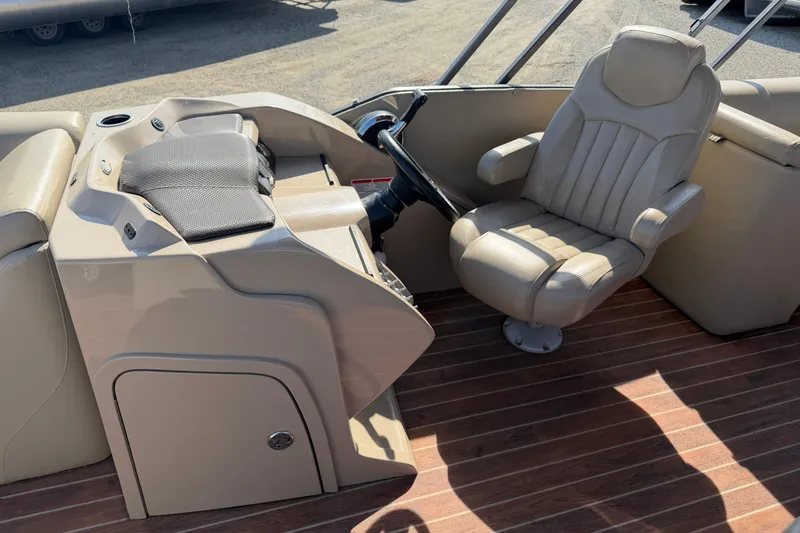 Slide: The Image of Captain's chair and helm of 2015 Crest Classic 230 SLC boat, featuring beige upholstery. - 8