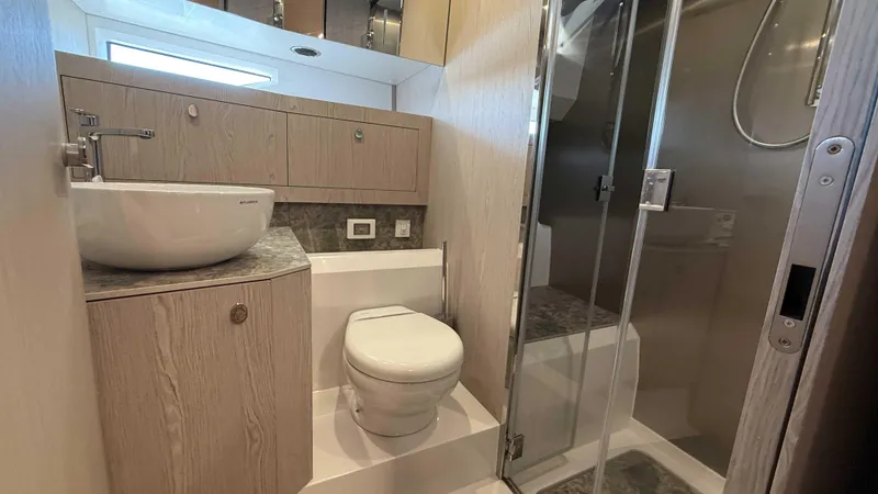 Slide: The Image of Modern yacht bathroom with sleek fixtures, glass shower, and wooden cabinetry in Santasevera52, 2026 model. - 21