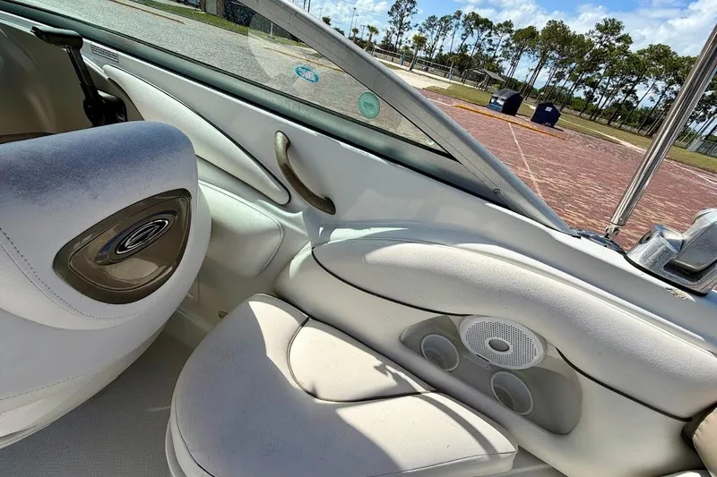 Slide: The Image of Interior of a 2005 Crownline 216 LS boat, featuring white seating and speaker system. - 13