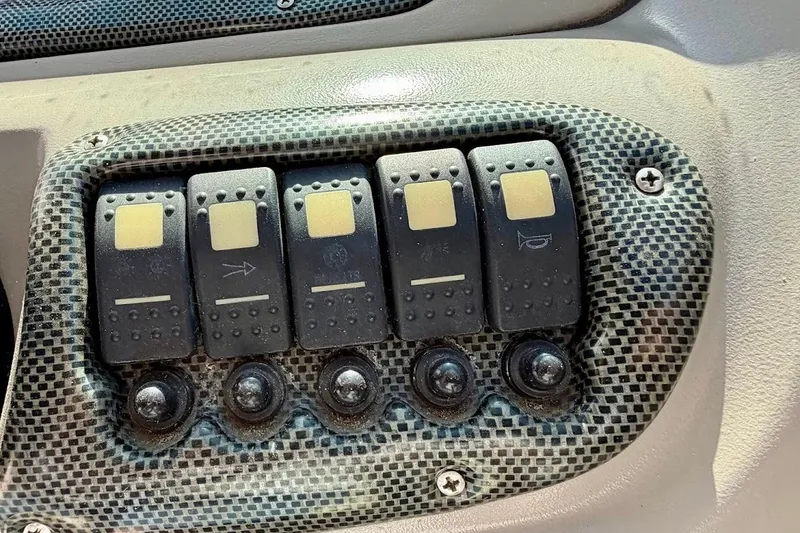 Slide: The Image of Control panel of a 2005 Crownline 216 LS boat with multiple switches. - 21
