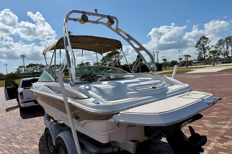 Slide: The Image of 2005 Crownline 216 LS boat on trailer, parked outdoors under a sunny sky. - 3