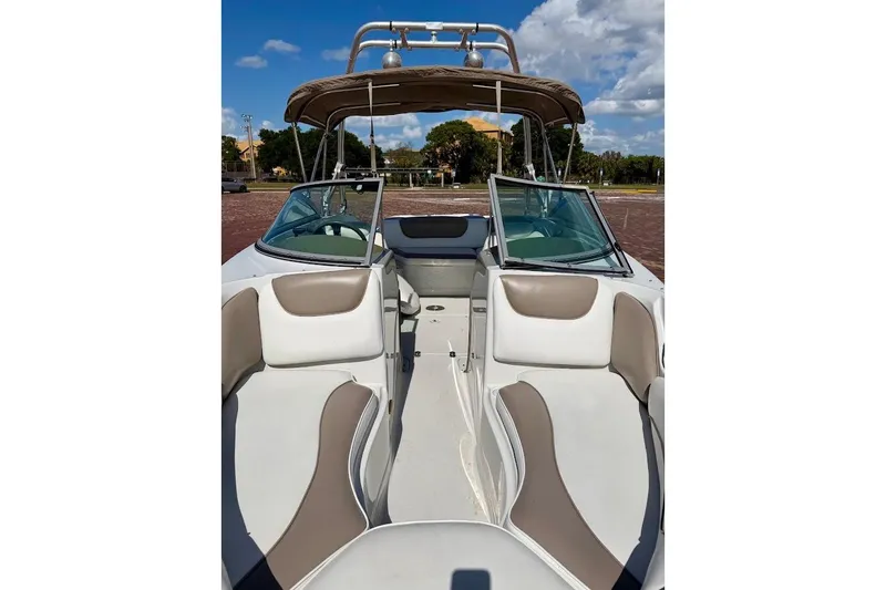 Slide: The Image of 2005 Crownline 216 LS boat interior with beige seating and open windshield under blue sky. - 6