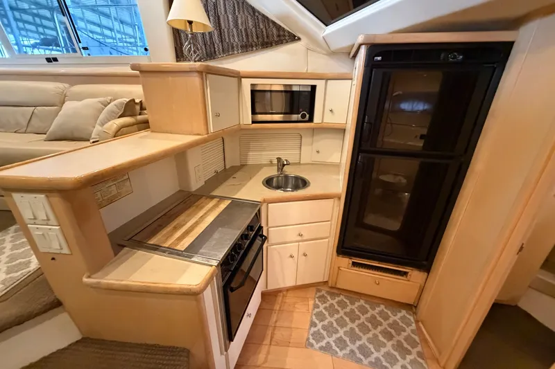 Slide: The Image of 1998 Carver 355 Aft Cabin Motor Yacht kitchen with stove, sink, and refrigerator. - 19