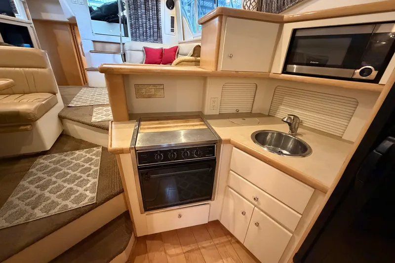 Slide: The Image of 1998 Carver 355 Aft Cabin Motor Yacht interior kitchen with stove, sink, and microwave. - 20