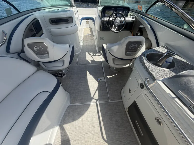 Slide: The Image of Interior of 2023 Crownline Eclipse E285 XS boat with steering wheel and seating area. - 13