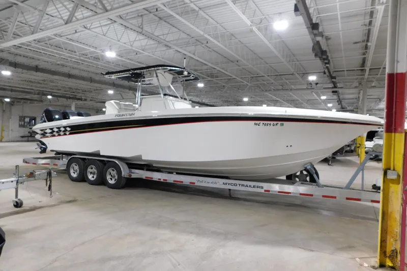 The Image of 2005 Fountain 34 Center Console boat on trailer in indoor storage facility. - 1
