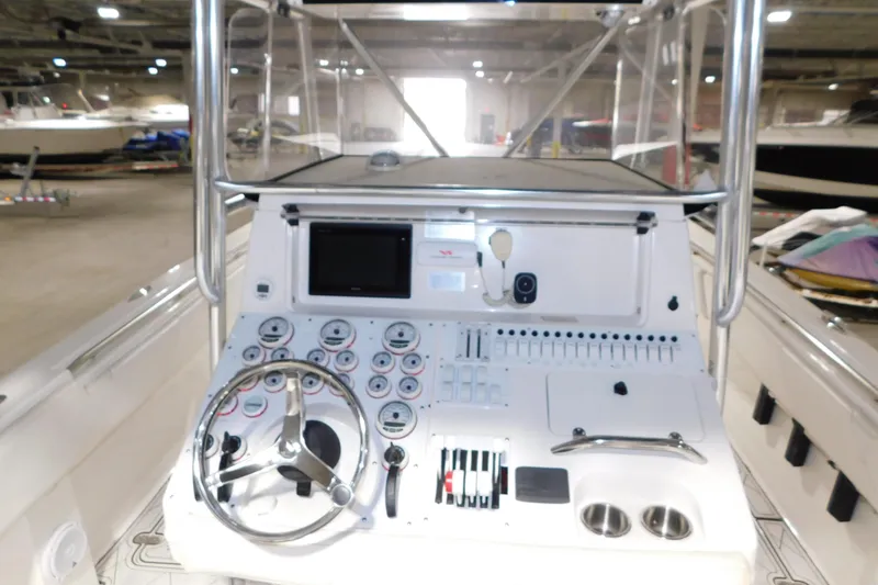 Slide: The Image of 2005 Fountain 34 Center Console boat dashboard with steering wheel and control panel. - 20