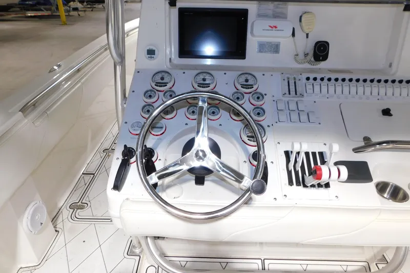 Slide: The Image of 2005 Fountain 34 Center Console boat dashboard with steering wheel and control gauges. - 24