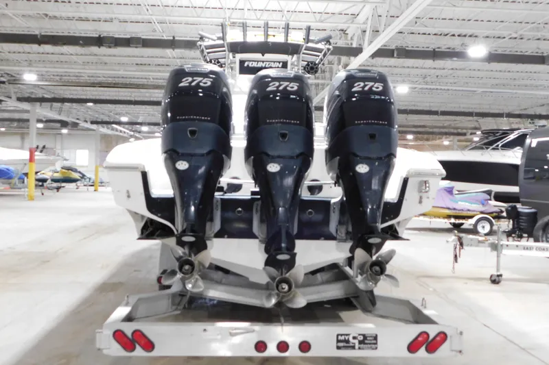 Slide: The Image of 2005 Fountain 34 Center Console boat with triple 275 horsepower engines in a storage facility. - 7