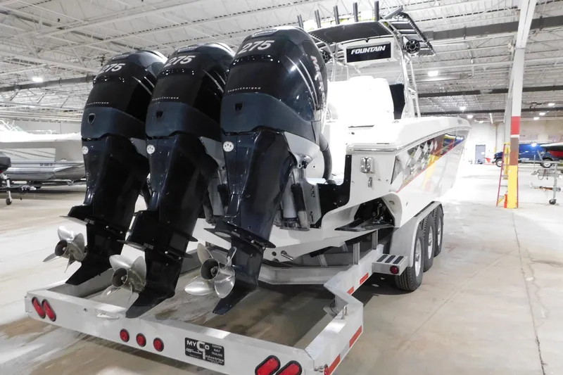 Slide: The Image of 2005 Fountain 34 Center Console boat with triple outboard engines on a trailer in a warehouse. - 8