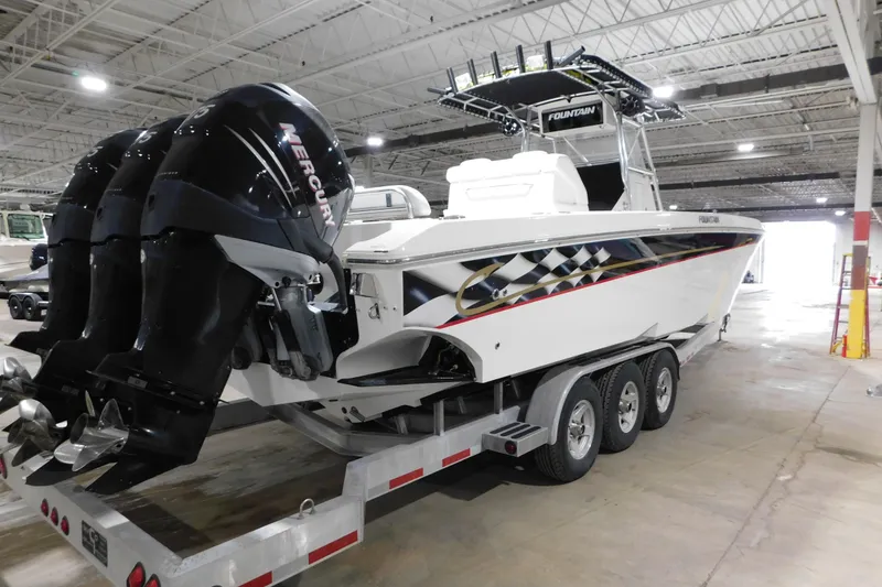 Slide: The Image of 2005 Fountain 34 Center Console boat with triple Mercury engines on a trailer. - 9