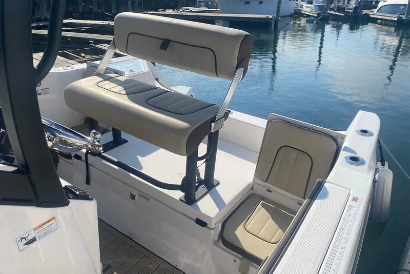 Slide: The Image of 2024 Yamaha Boats 222 FSH Sport E interior seating, docked at marina. - 12
