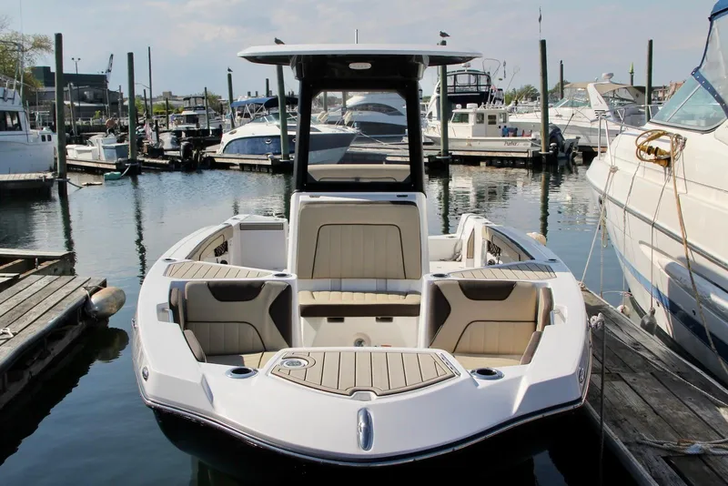 Slide: The Image of 2024 Yamaha Boats 222 FSH Sport E docked in a marina, showcasing sleek design and spacious seating. - 2