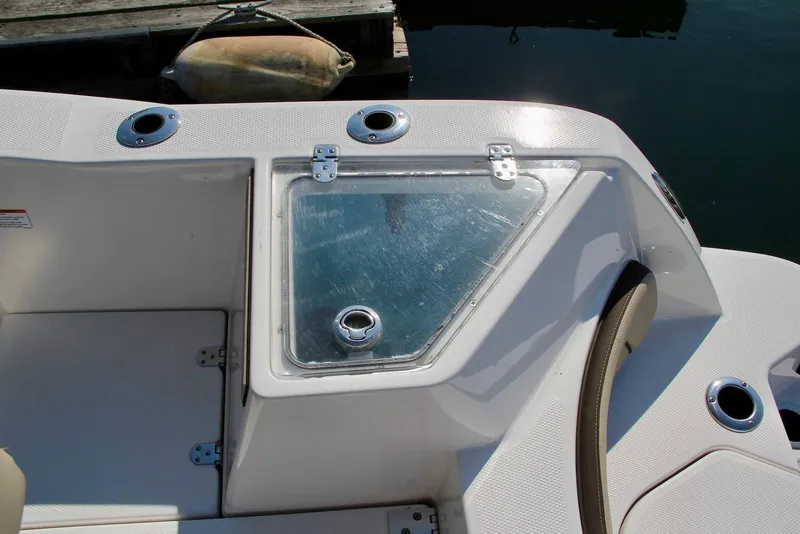 Slide: The Image of 2024 Yamaha Boats 222 FSH Sport E deck with storage compartment and cup holders. - 3