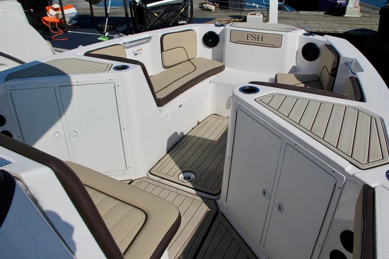 Slide: The Image of 2024 Yamaha Boats 222 FSH Sport E interior with cushioned seating and storage compartments. - 5