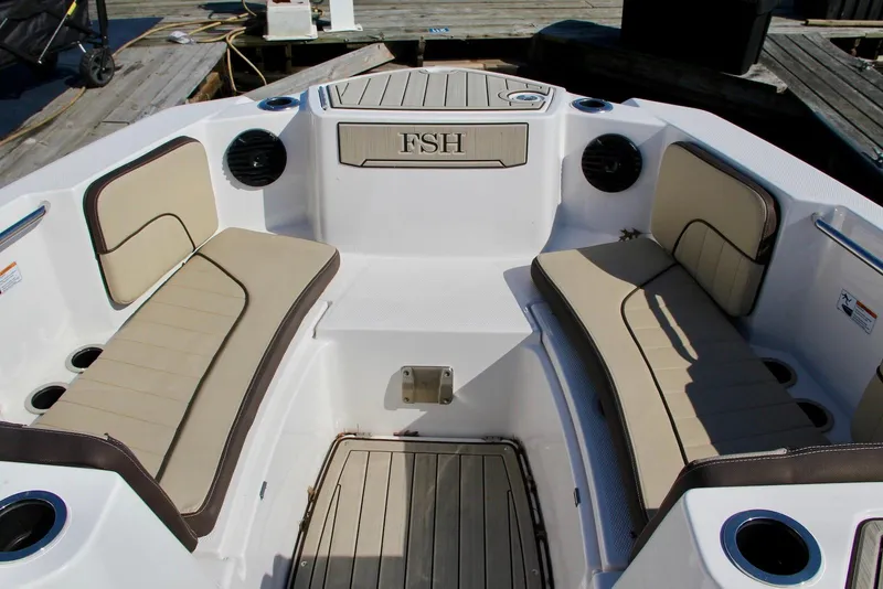 Slide: The Image of 2024 Yamaha Boats 222 FSH Sport E interior with cushioned seating and cup holders. - 6