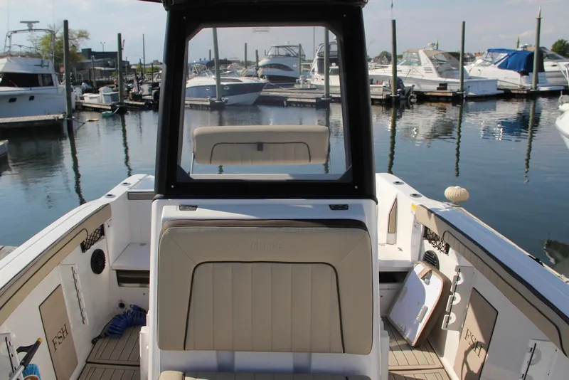 Slide: The Image of 2024 Yamaha Boats 222 FSH Sport E at marina, showcasing interior seating and helm. - 7